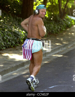 Sparky George 55, of Danville, Calif., heads out on a run with an American flag around his waist in Danville, Calif., on Tuesday, July 6, 2004. George's running is a tribute to servicemen and women who had died in Iraq and Afghanistan. He hit the road out of dedication and outrage, after learning th Stock Photo