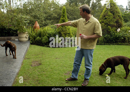 Tony Garza, US Ambassador to Mexico, relaxes in the backyard of his residence playing fetch with his chocolate labradors and a taquila shot on the evening of Thursday July 29, 2004.  (Photo By Sarah Martone) Stock Photo