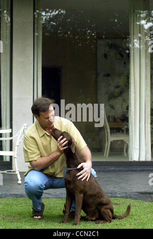 Tony Garza, US Ambassador to Mexico, pets Milo, one of his chocolate labradors, in the backyard of the Ambassador's residence in Mexico City on the evening of Thursday July 29, 2004 as his work day winds down.  (Photo By Sarah Martone) Stock Photo