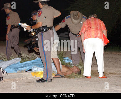 STATE/DAILY/ UNDOCUMENTED ACCIDENT: DPS and local Justice of the Peace Rosa Trevino examine the bodies of 9 undocumented immigrants who drowned after their car fell into an irrigation canal south of McAllen, Texas early Tuesday morning Aug.10, 2004.DELCIA LOPEZ/STAFF Stock Photo