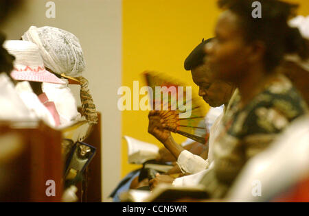 Aug 17, 2004; Miami, FL, USA; A Haitian woman fans herself during a revival service at the Haitian Baptist Church of the Living God in the Little Haiti neighborhood of Miami, FL on Tuesday, August 17, 2004. Stock Photo