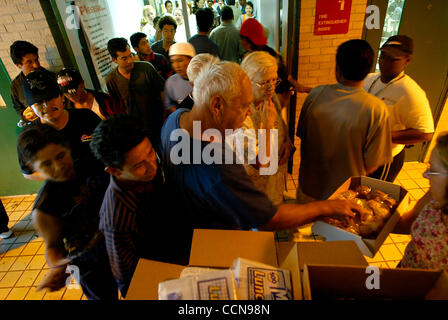 Sep 04, 2004; West Palm Beach, FL, USA; Hurricane Frances, one of the slowest moving hurricanes in memory, lumbered ashore onto Florida's east coast on Saturday, September 4, 2004 bringing hurricane force winds and heavy rains. Richard Haekler (blue shirt) of North Palm Beach reaches for a muffin as Stock Photo