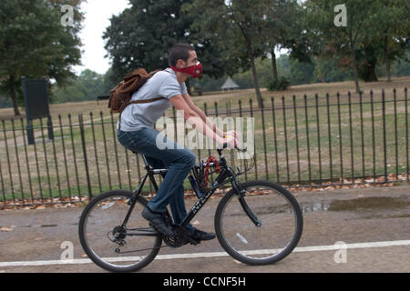 Oct 05, 2004; London, UK; A Cyclist on his bike wearing a face mask to help keep out the air pollution. In the city pollution from cars and traffic is heavy and can cause breathing respiratory problems. Global warming possibly caused air pollution is a threast to the health of the world. Stock Photo