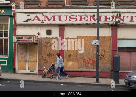 Oct 05, 2004; Leeds, UK; A woman and child walk past a run down and disused part of Leeds with boarded up windows and closed stores. Poor economy and depression are common sights in much of the UK due to recession through 1980's and early 90's. Stock Photo