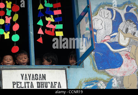 JAKARTA,  INDONESIA  NOVEMBER 29, 2004    Four kindergarten pupils of TK Pelita Dhu'afa take a peek outside a window of the school's second floor in Kalibaru, Jakarta Utara. It was once a modest garage with roughly cemented floor. Since 1994, the school is provided and managed for free by Mrs. Endri Stock Photo