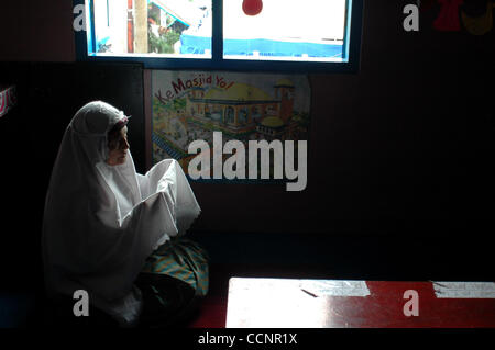 JAKARTA,  INDONESIA  NOVEMBER 29, 2004    Endrizaemi, known as 'Ibu Haji', prays after finishing her shalat at the founded school that was once a garage. Besides working as the head of public elementary school, SD Negeri 03 Marunda, she also teaches in a school for the orphans and abandoned children Stock Photo