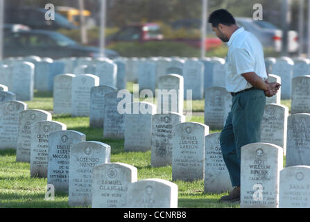 For most of the cemetery workers here at Golden Gate National Cemetery, burials of veterans is an honor.They settled 600 vets and family members into the ground last year alone. Following a full military honors burial for Marine Erick Hodges Friday, November 19, 2004, a cemetery workers waits a resp Stock Photo