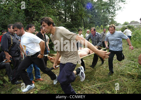 Five years on from the Beslan school siege ; pictured: local people rescuing school children - hostages. Stock Photo