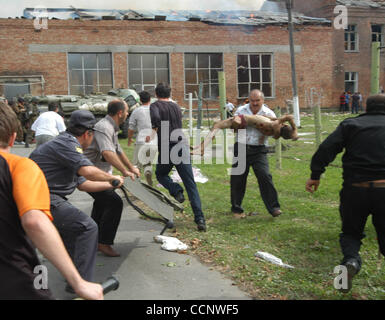 Five years on from the Beslan school siege ; pictured: local people rescuing school children - hostages. Stock Photo