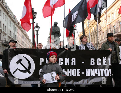 Russian nationalists of the forbidden National Bolshevik party (NBP)with their flags and symbolics at a protest rally in St.Petersburg. Russian radical nationalists protested against NATO . The rally was held under nationalistic slogan (on the placard) of : `Russia Above All, All the Rest is Nothing Stock Photo