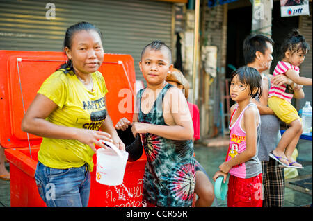 Locals fill their buckets with water during the Songkran festival at Khao San road, a popular tourist area in Bangkok. Songkran is the traditional Thai New Year festival. The most obvious celebration of Songkran is the throwing of water. Stock Photo