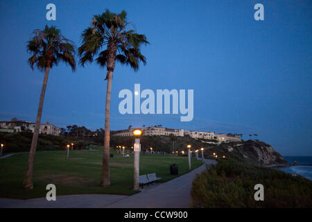 May 31, 2010 - Dana Point, California, U.S. - Palm trees at sunset on Salt Creek beach with Ritz Carlton hotel on the hill in moonlight. Monarch Beach is a small, wealthy gated community in Orange County, California located within Dana Point. Its distinction is the St. Regis and the Ritz Carlton-Lag Stock Photo