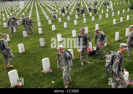 Soldiers from the 3rd U.S. Infantry Regiment (The Old Guard) place more than 250,000 grave decorating flags at Arlington National Cemetery on Thursday, May 27 2010. The “Flags In” ceremony has been a tradition on Memorial Day weekend for over 60 years. Stock Photo