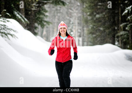 Apr. 01, 2010 - Spokane, Washington, USA - Linda Lilard is an elite runner with the running club Team Swift based out of Spokane, Washington. She runs at Mt. Spokane Ski Resort on a snowy spring day dressed in winter running gear and running through evergreen trees, snow, trails on a cloudy winter l Stock Photo