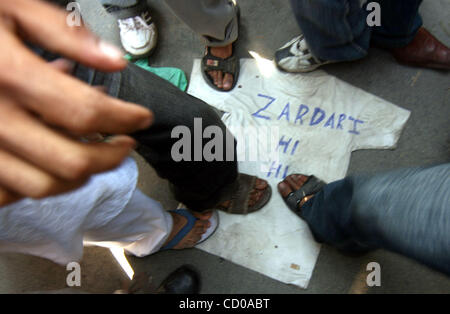 Kashmiri Muslim protestors use feet on shirt of a effigy made as  Pakistani President Asif Ali Zardari after his recent statement in which he described Kashmiri's as Militants during a protest against Indian Prime Minister Manmohan Singh's visit in Srinagar-Summer capital of Indian Kashmir October 1 Stock Photo
