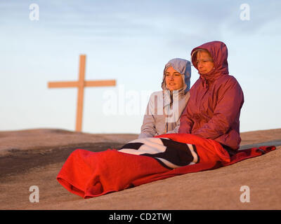 University of Georgia students, Beth Roger, left, and Haylee Humes, right, watch the sunrise during the Easter Sunrise Service on the summit of Stone Mountain, Ga. The world's largest piece of exposed granite, Stone Mountain rises 1,863-feet above sea level and it is home to the world's largest reli Stock Photo