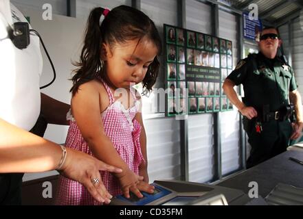 Apr 10, 2008 - Fort Pierce, Florida, USA - ALEX BLANCO, 4, gets her finger prints scanned for a ID Fingerprint Card that is  record for parents to keep of their child's picture, fingerprints and demographics while attending the first night of the St. Lucie County Sheriff's Office DARE Carnival on Th Stock Photo