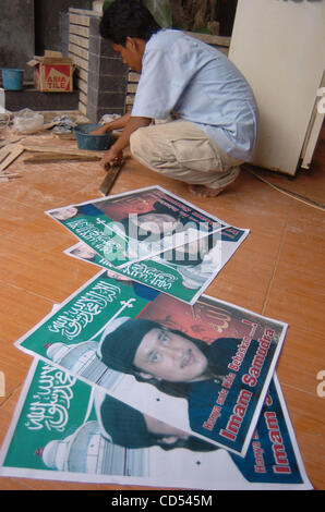 A relative of Bali bomber Imam Samudra makes a frame on posters of Imam Samudra in his brother's home at in Serang, Banten province, Indonesia, Nov 5, 2008. Three Indonesian militants on death row for the 2002 Bali bombings have exhausted legal options and cannot prevent their executions, a Supreme  Stock Photo
