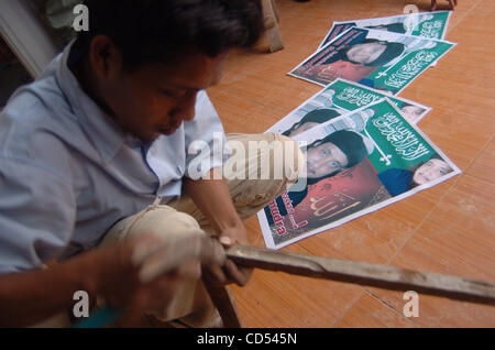 A relative of Bali bomber Imam Samudra makes a frame on posters of Imam Samudra in his brother's home at in Serang, Banten province, Indonesia, Nov 5, 2008. Three Indonesian militants on death row for the 2002 Bali bombings have exhausted legal options and cannot prevent their executions, a Supreme  Stock Photo
