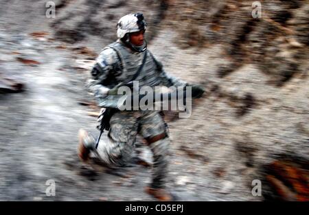 May 02, 2008 - Paktya Province, Afghanistan -  In the late afternoon SPECIALIST MAURICE NESBITT of the 101st Abn., moves quickly downhill, carrying a mortar tube, during his platoon's patrol in eastern Afghanistan mountains looking for observation and rocket-launching sites used by the Anti-Coalitio Stock Photo