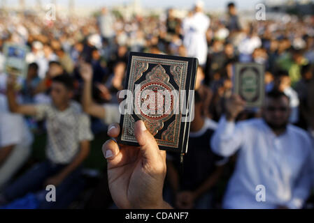 Sept 10, 2010 - Beit Lahiya, Gaza Strip - Palestinian men hold up the Quran, Islam's holy book, in reaction to a small American church's plan to burn copies of the Quran during a prayer as part of tradition during the first day of Eid al-Fitr which marks the end of the Muslim fasting month of Ramada Stock Photo