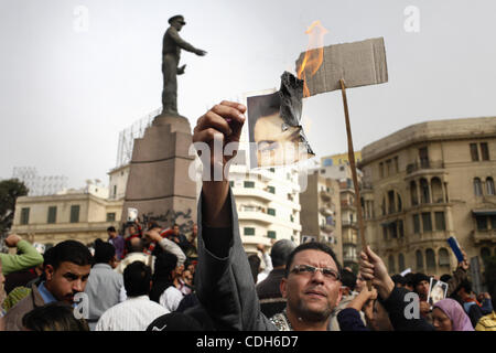 Jan. 29, 2011 - Cairo, Cairo, Egypt - .A protester burned a photo of Mubarak in front of the statue of a famous military general near Tahrir...After yesterdays march from friday prayer into Tahrir the square was cleared, and refilled with army personnel.  Throughout the day protesters continued to c Stock Photo