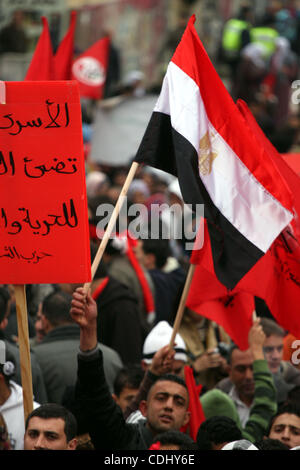 Palestinians wave an Egyptian flag and red flags during a demonstration marking the 29th anniversary of the Palestinian People's Party, a socialist political party, in the West Bank city of Ramallah, Saturday, Feb. 12, 2011. Photo by Issam Rimawi Stock Photo