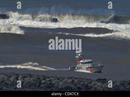Mar. 11, 2011 - Wichester Bay, Oregon, U.S - A United States Coast Guard surf rescue boat enters the mouth of the Umpqua River near the community of Winchester Bay along the southern Oregon coast.  The boat was heading back to port after the danger of the tsunami had passed. A  tsunami warning was i Stock Photo