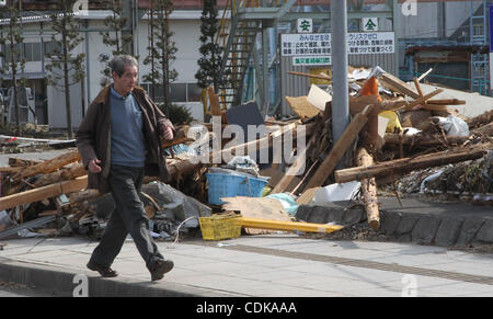 Mar. 14, 2011 - Kamaishi, Japan - Man walks by rubble in Kamaichi, Iwate, Japan. Magnitude 9.0 earthquake hit Northern Japan. Several tens of thousands of people are still missing. (Credit Image: © Junko Kimura/Jana Press/ZUMAPRESS.com) Stock Photo