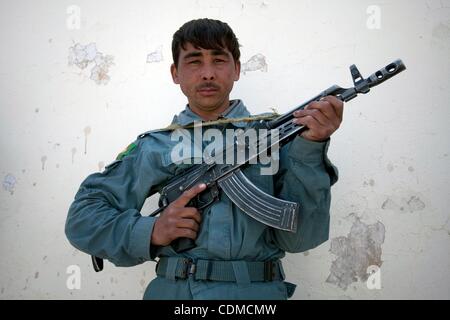 Apr 05, 2011 - Kandahar, Afghanistan - Automatic weapon in hand, a member of the Afghan National Police from the northern province of Kunduz outside the Dand district Center. This officer only speaks Dari and so cannot communicate with the local population who overwhelmingly speaks Pashto, the other Stock Photo
