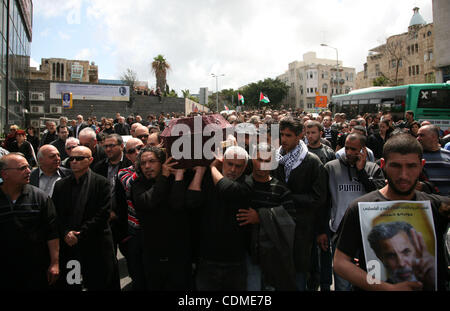 People carry the coffin of Arab-Israeli actor and director Juliano Mer Khamis during a funeral procession near al-Midan theater in the northern Israeli city of Haifa April 6, 2011. Mer-Khamis was gunned down Monday in the West Bank town where he ran a drama school and community theater, and was laid Stock Photo