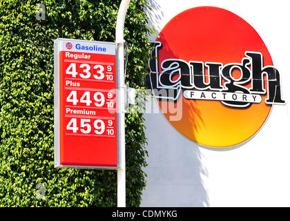 A comedy club sign is seen near gas prices posted in the $4.00 range at a 76 station in Hollywood, California on April 16, 2011.  With the price of gas above $3.50 a gallon in all but one state, there are signs that Americans are cutting back on driving, reversing a steady increase in demand for fue Stock Photo