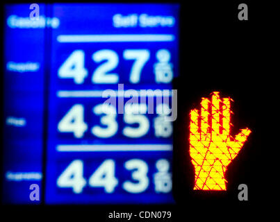 A don't walk sign flashes near gas prices posted in the $4.00 range at a Chevron station in Los Angeles, California on April 17, 2011.  With the price of gas above $3.50 a gallon in all but one state, there are signs that Americans are cutting back on driving, reversing a steady increase in demand f Stock Photo