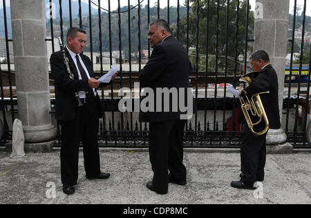 Apr 21, 2011 - Quetzaltenago, Guatemala - Preparing to play funeral marches members of  the band that will be accompanying the Procession of the Just Judge look over their music before the procession  of the Just Judge begins. The Procession of the Just Judge will take the Saint Statues to the Presi Stock Photo