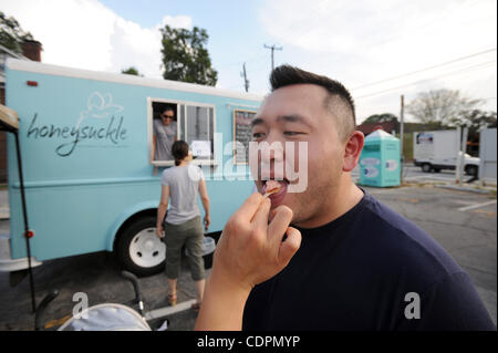 July 13, 2011 - Atlanta, GA, U.S. - ATLANTA, GA - JULY 13: Ray Peng is fed some gelato by his wife Ashley from the Honeysuckle food truck in a parking lot in the Virginia-Highland neighborhood in Atlanta, Georgia on Wednesday, July 13, 2011.  PHOTO CREDIT: ERIK S. LESSER FOR THE NEW YORK TIMES (Cred Stock Photo