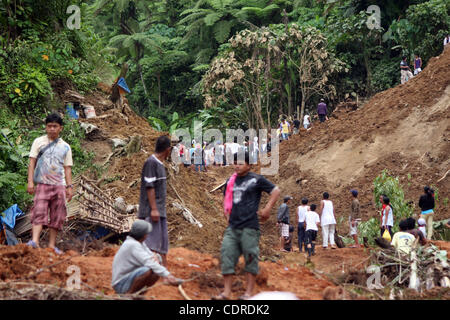 Apr 23, 2011 - Pantukan, Compostella Valley, Philippines - Locals are seen at the landslide site where rescuers search for people missing Saturday after an avalanche of mud buried an illegal gold mining camp on Friday, April 22, 2011 in the town of Pantukan in Compostella Valley in the southern Phil Stock Photo