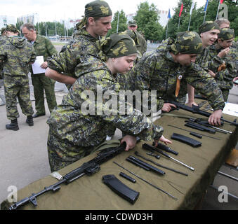 Russian teenagers are getting military skills during the summer training camp Zarnitsa for teenages organized by military-patriotic club.The event is taking place at the military base of 27th Rifle-infantry division near Moscow. Pictured: Russian girls teenagers disassembling Kalashnikov submachine  Stock Photo