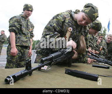 Russian teenagers are getting military skills during the summer training camp Zarnitsa for teenages organized by military-patriotic club.The event is taking place at the military base of 27th Rifle-infantry division near Moscow. Pictured: Russian girls teenagers disassembling Kalashnikov submachine  Stock Photo