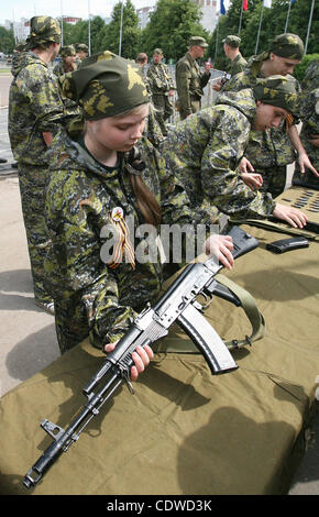 Russian teenagers are getting military skills during the summer training camp Zarnitsa for teenages organized by military-patriotic club.The event is taking place at the military base of 27th Rifle-infantry division near Moscow. Pictured: Russian girls teenagers disassembling Kalashnikov submachine  Stock Photo