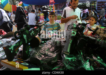 Aug. 29, 2011 - Gaza City, Gaza Strip - Palestinian vendors display toy machine guns and goods for sale during preparations for Eid al-Fitr at the main market, in Gaza city. Muslims throughout the world buy clothes, sweets and other popular items to prepare for The Eid aL-Fitr ,the festivities marki Stock Photo