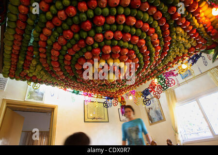 Oct 10, 2011 - Nablus, Gaza Strip - A woman from the ancient Samaritan community decorates a Sukkah made from fresh fruit for the holiday of the Tabernacles, or Sukkot, in Mount Gerizim near the West Bank town of Nablus. The Sukkah is a temporary structure built for the Jewish holiday Sukkot, which  Stock Photo