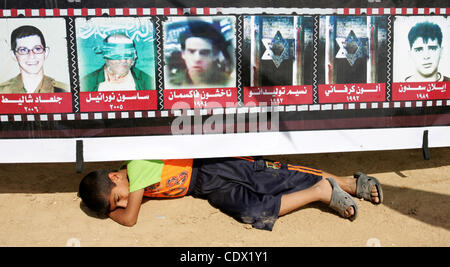 Oct. 19, 2011 - Khan Yunis, Gaza Strip, Palestinian Territory - A Palestinian boy sleeps under a poster for Kidnaped Israeli soldiers by Palestinian militants laid at the reception tent of  Hamas freed Palestinian prisoner Yehia Sinwar laid upon his return in the southern Gaza Strip town of Khan Yun Stock Photo