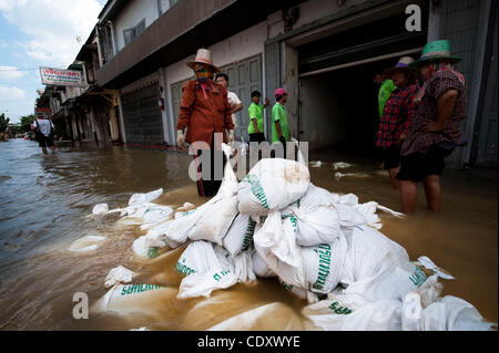 Oct. 31, 2011 - Bangkok, Bangkok, Thailand - Workers move sandbags into the flooded warehouse to prevent further overflow of the floodwaters into residential and business area of Chinatown. Although most of the small businesses are flooded in Chinatown district of Bangkok, shops remain open despite  Stock Photo
