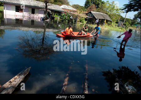 Nov. 2, 2011 - Bangkok, Bangkok, Thailand - Residents of the Klong make their way through floodwaters in Klong Sanva, Bangkok..Bangkok Governor Sukhumbhand Paribatra ordered police to protect a levee on the cityâ€™s outskirts after thousands of people damaged the floodgate, threatening inner parts o Stock Photo