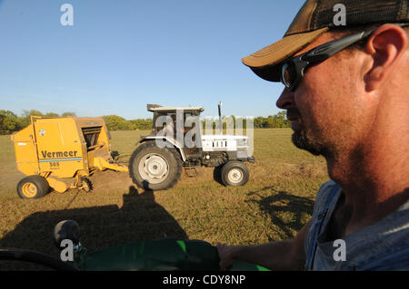 Sep. 28, 2011 - Clinton, Missouri, U.S. - Jared rides his vintage Oliver 77 tractor, as his Father Willie Lawler bales hay. Raking hay on a neighbors plot of land in trade for hay. (Credit Image: &#169; Josh Bachman/ZUMA Press) Stock Photo