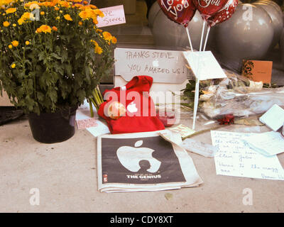 The Apple Store at 679 N. Michigan Avenue becomes a memorial shrine.  People mourning Steve Jobs recent death show their grief by leaving flowers, lit candles, and by attaching personal messages in colorful post-it notes to the window of the store.  The messages are in multiple languages.  People ha Stock Photo