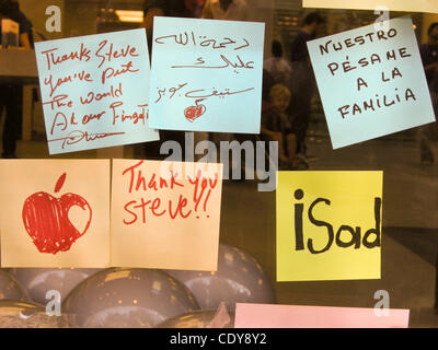 The Apple Store at 679 N. Michigan Avenue becomes a memorial shrine.  People mourning Steve Jobs recent death show their grief by leaving flowers, lit candles, and by attaching personal messages in colorful post-it notes to the window of the store.  The messages are in multiple languages.  People ha Stock Photo