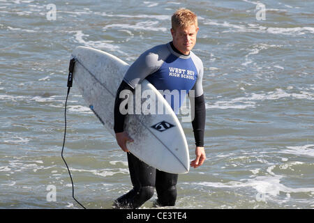 Trevor Donovan Cast members of the television show '90210' film a beach scene with wetsuits and surfboards in Malibu. Los Angeles, California - 22.11.10 Stock Photo