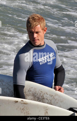 Trevor Donovan Cast members of the television show '90210' film a beach scene with wetsuits and surfboards in Malibu. Los Angeles, California - 22.11.10 Stock Photo