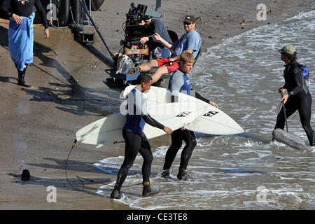 Trevor Donovan and Tristan Wilds Cast members of the television show '90210' film a beach scene with wetsuits and surfboards in Malibu. Los Angeles, California - 22.11.10 Stock Photo